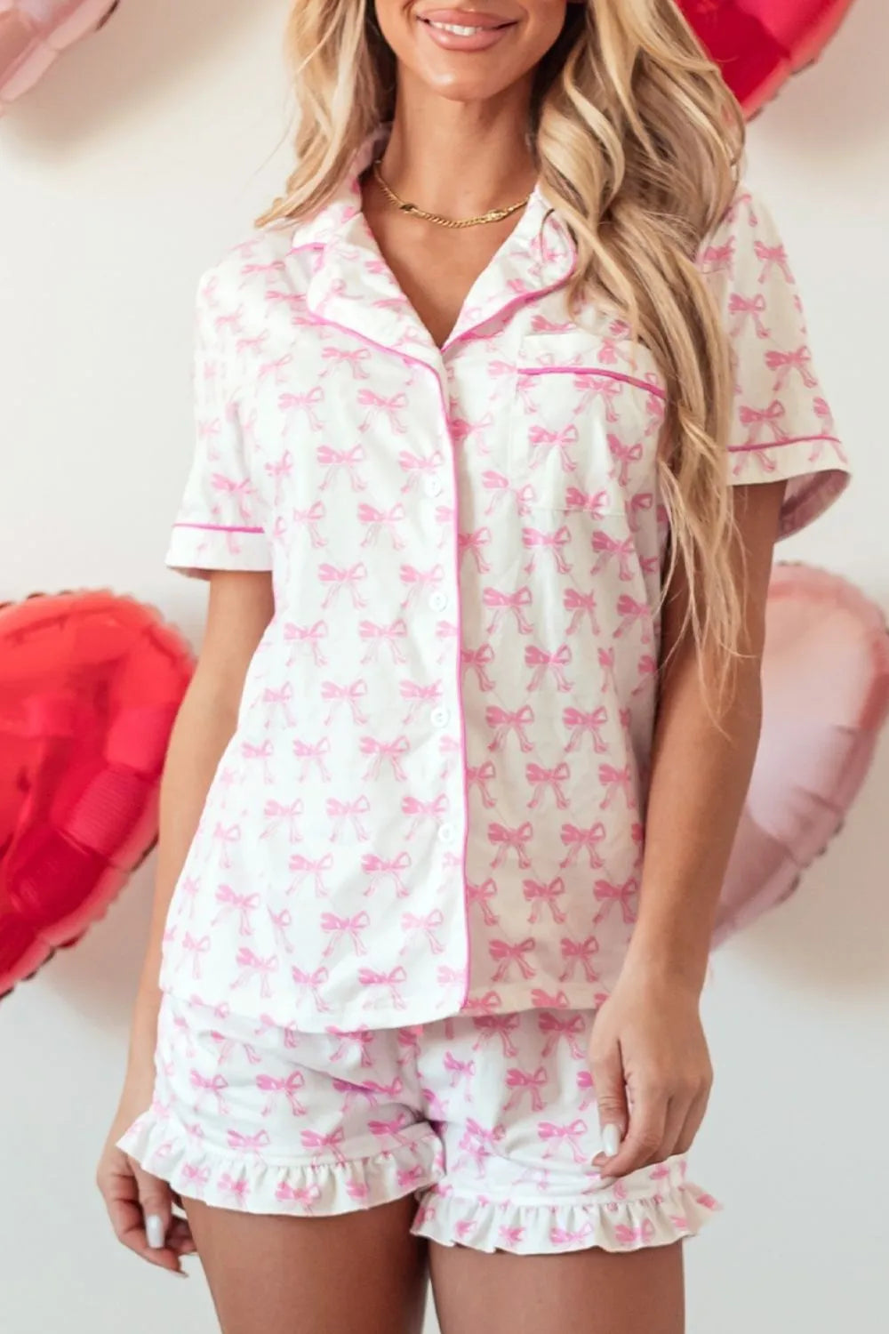 Woman wearing white and pink bow print shirt and shorts lounge set with frill hem and pockets