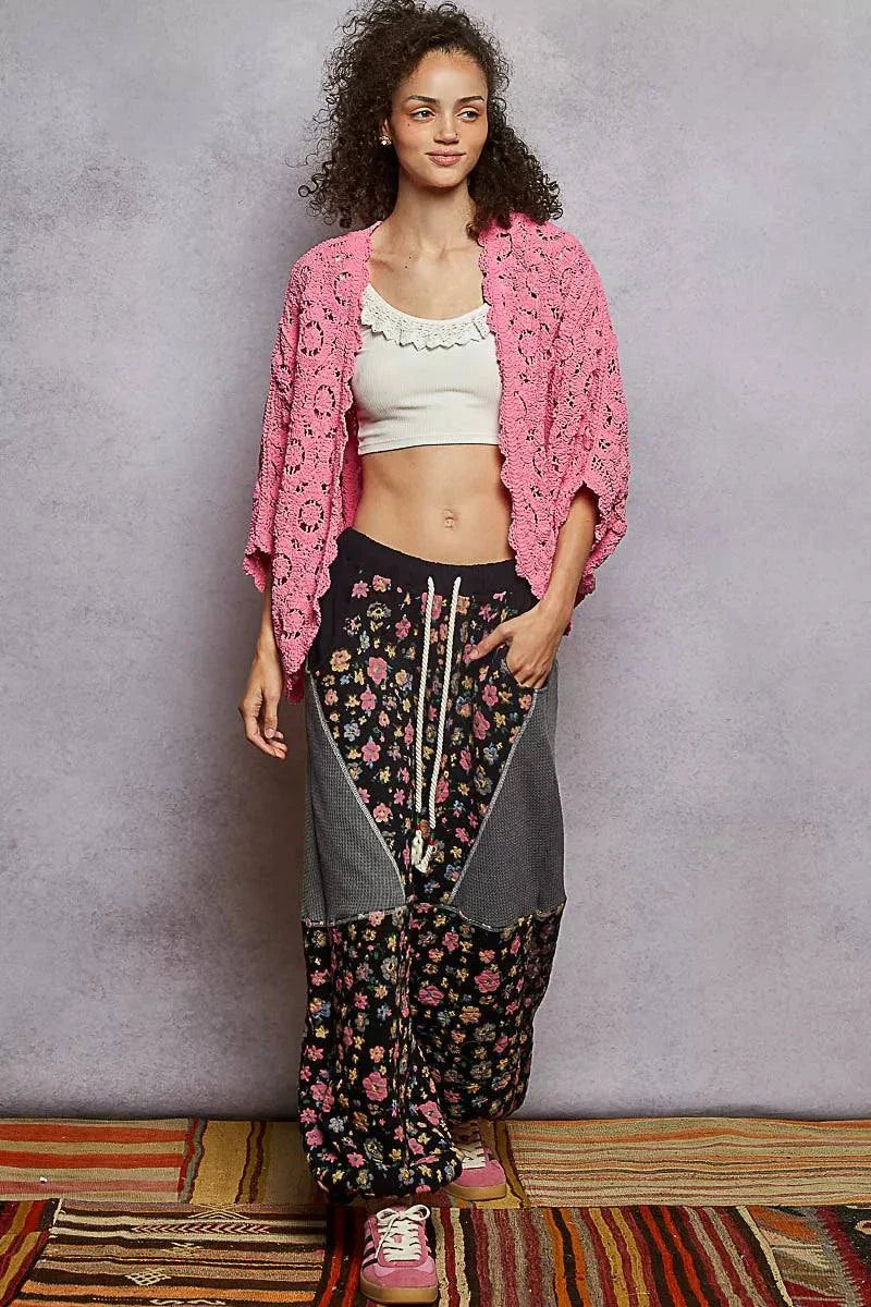 Woman wearing pink POL Floral Pattern open front cardigan with batwing sleeves and floral print pants