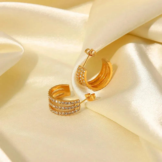 Gold-plated stainless steel C-hoop earrings with zircon inlays on satin background