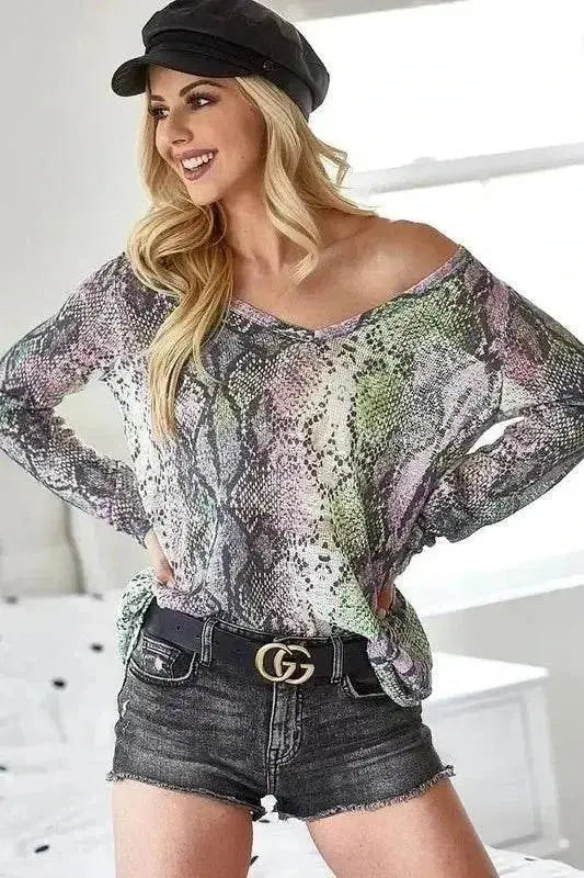 Woman wearing BiBi Snakeskin Print low gauge Hacci V-neck top with black hat and denim shorts