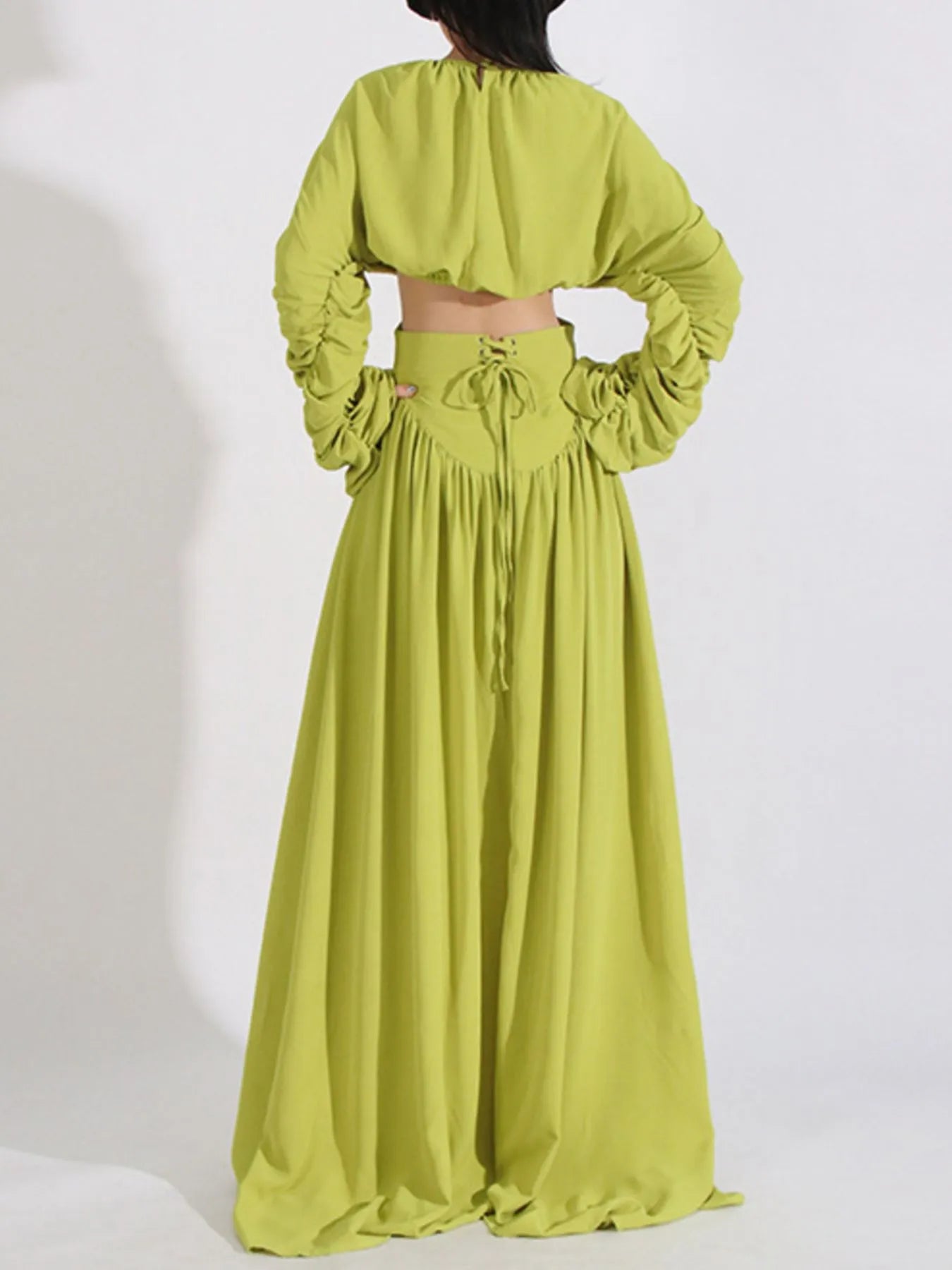 Back view of lime green ruched long sleeve top and high waist skirt set with tied details
