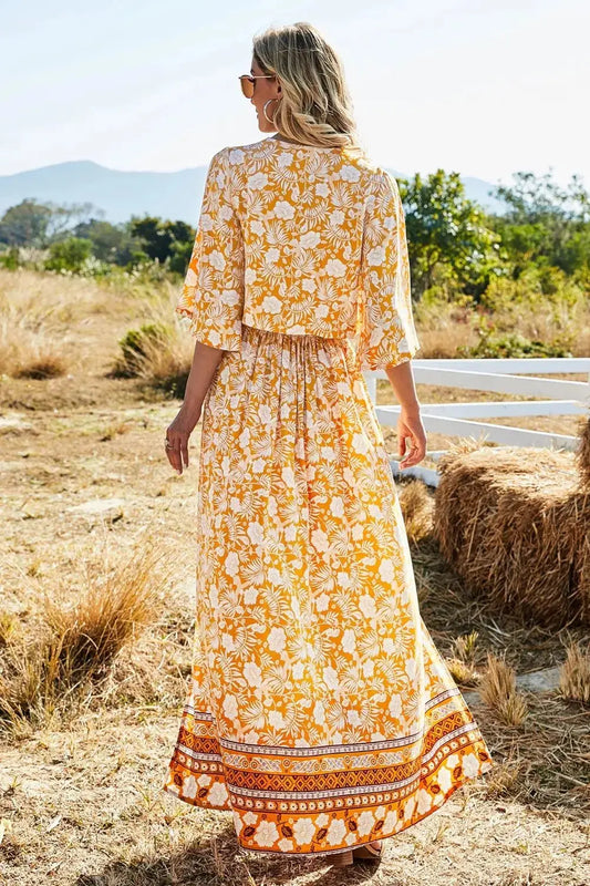 Woman wearing printed half sleeve top and slit skirt set in yellow floral pattern outdoors