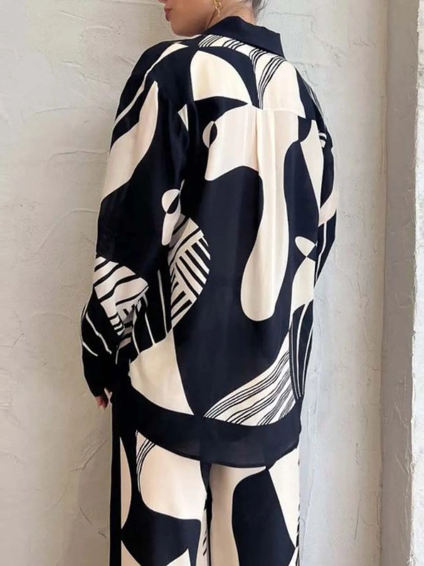 Printed long sleeve shirt and pants set with abstract black and white design, buttoned and pocketed, made of 100% polyester.