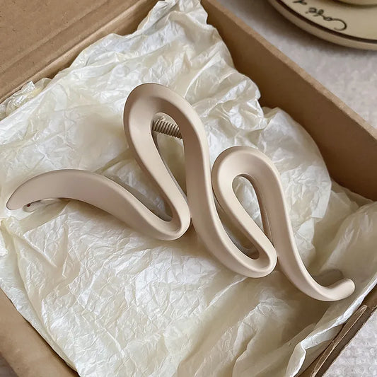 Neutral beige alloy acrylic hair claw clip with wavy design in a box