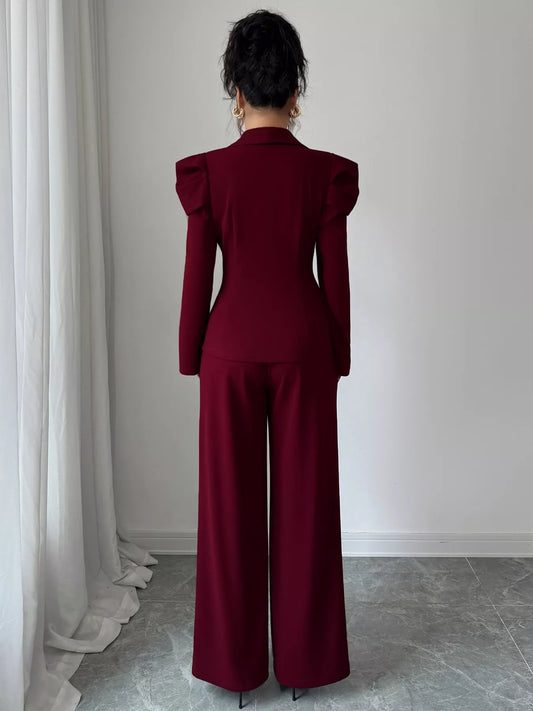 Woman wearing a burgundy double-breasted blazer and pants suit set, back view