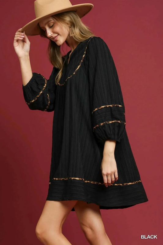 Umgee Plus Size Babydoll Dress in black with textured fabric and leopard trim detail, styled with a hat