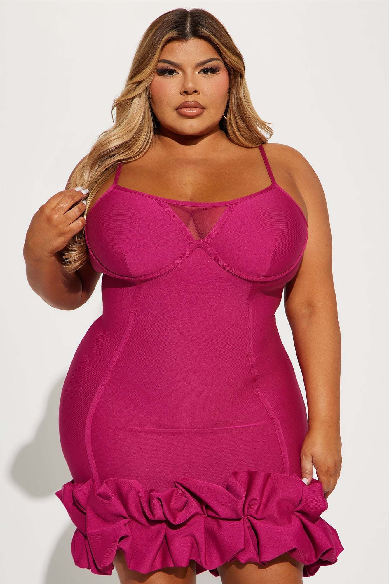 Plus size model wearing a pink Everly Bandage Mini Dress with ruffled hem and thin straps