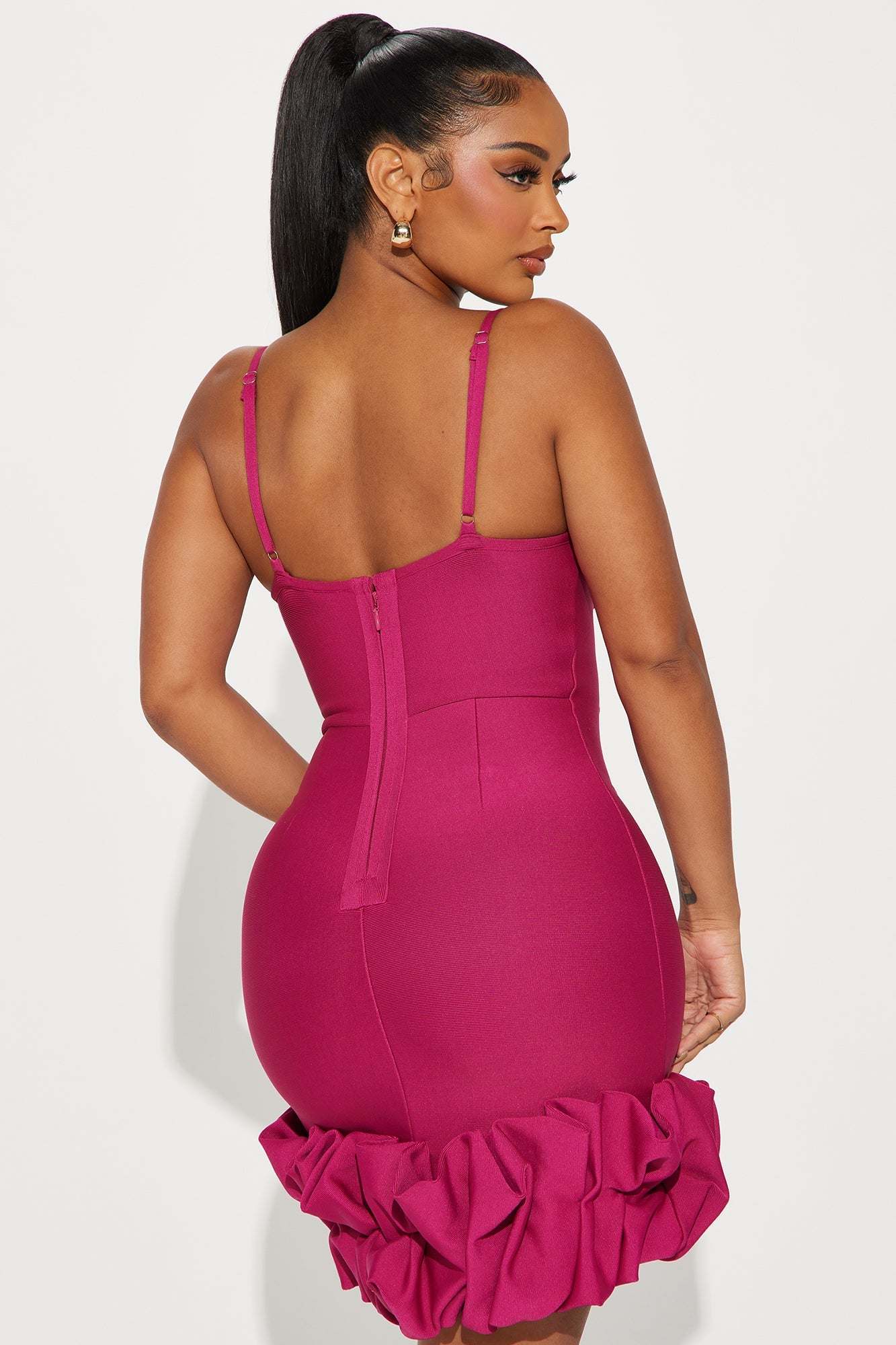 Woman wearing a fuchsia Everly Bandage Mini Dress with ruffled hem viewed from the back