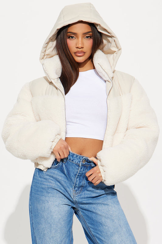 Woman wearing cream Up North Sherpa cropped puffer jacket with removable hood and toggle waist detail