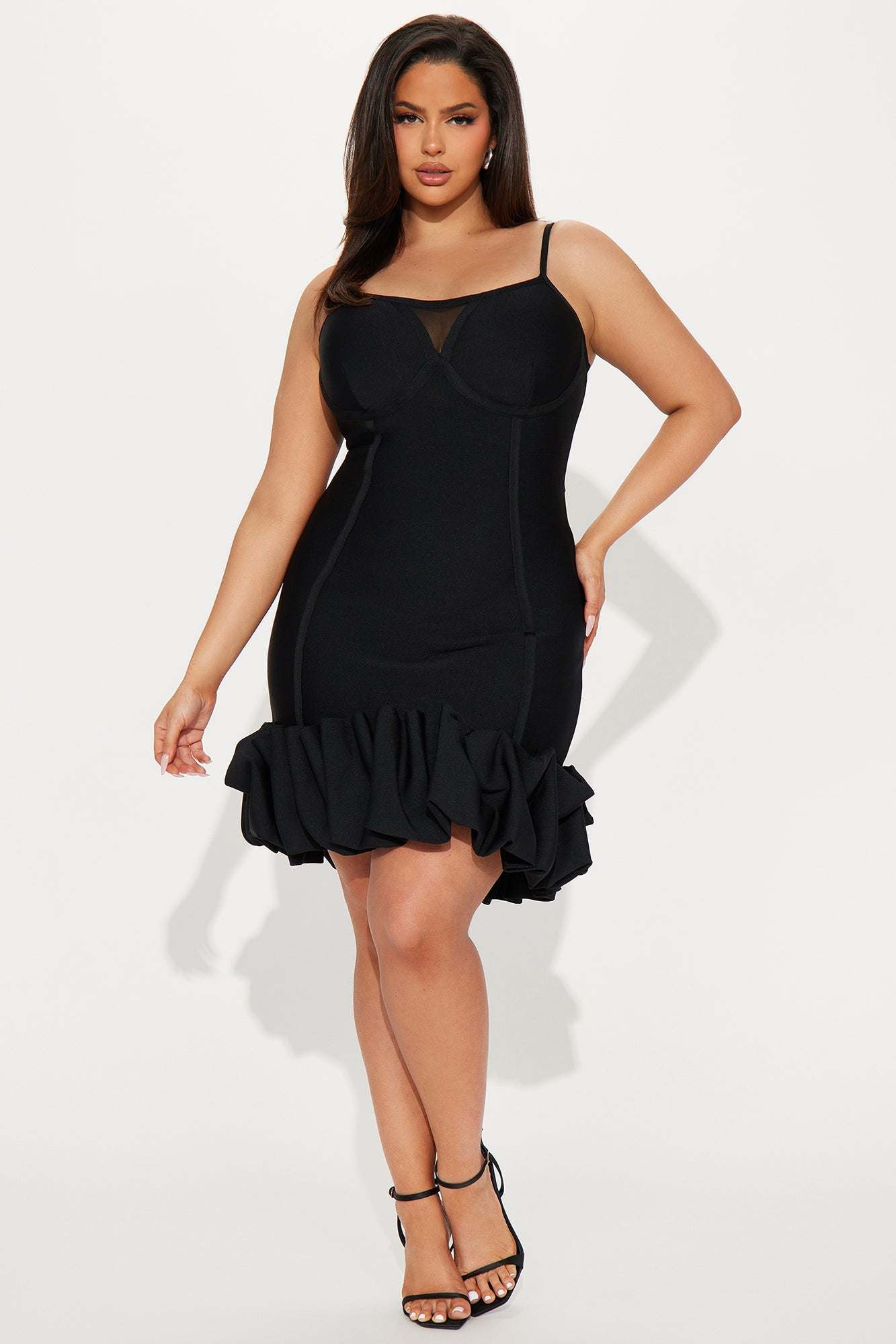 Woman wearing black Everly Bandage Mini Dress with ruffled hem and spaghetti straps