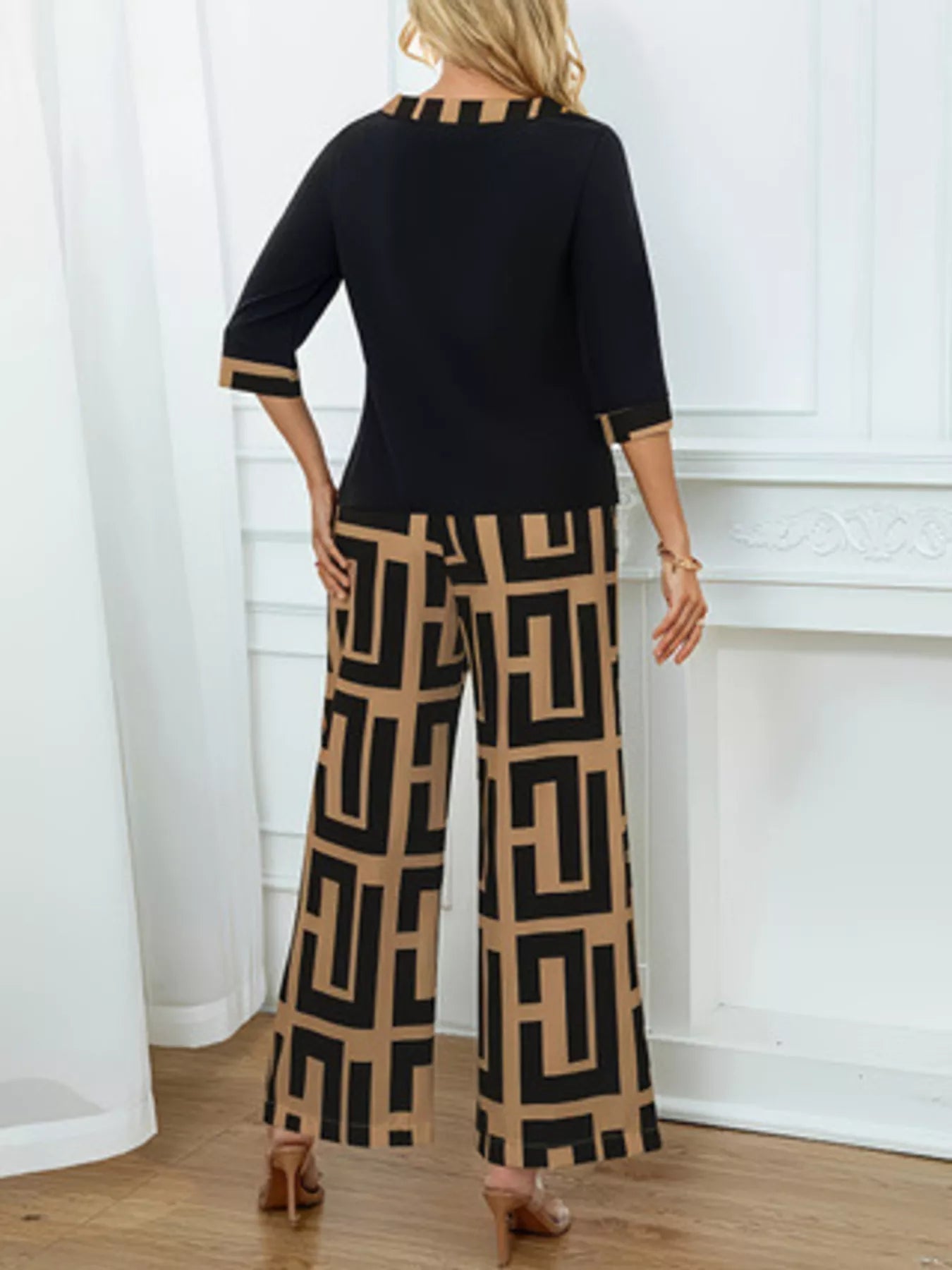 Woman wearing geometric print round neck top and matching wide-leg pants two-piece set seen from the back