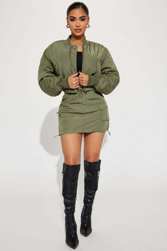 Olive bomber skirt set with cropped zip-up jacket and cargo pocket mini skirt styled with black knee-high boots