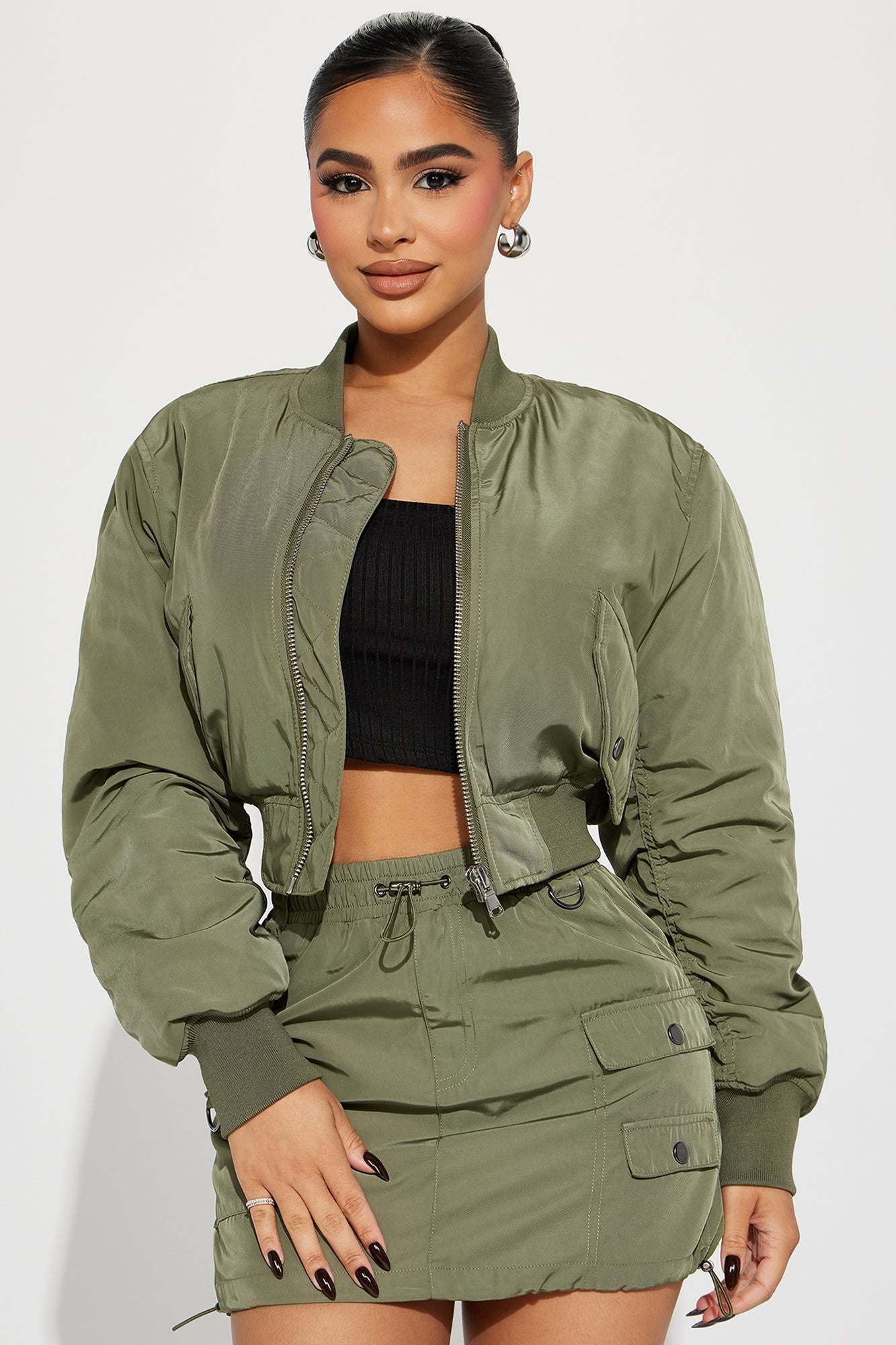 Woman wearing olive bomber skirt set with cropped jacket and mini skirt with cargo pockets