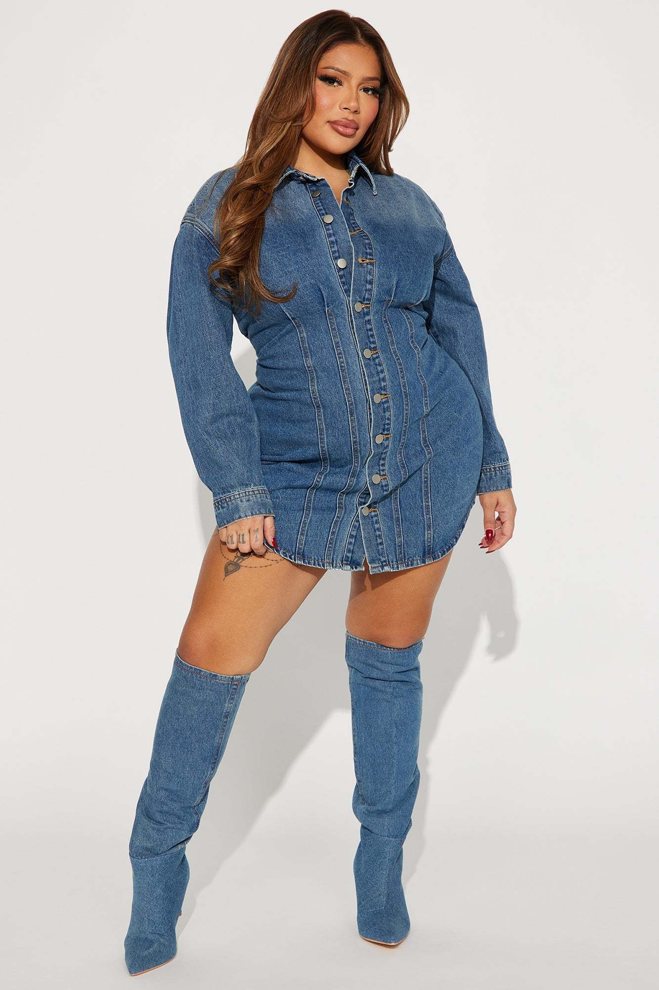 Woman wearing Alessandra denim mini dress in medium wash with matching knee-high boots