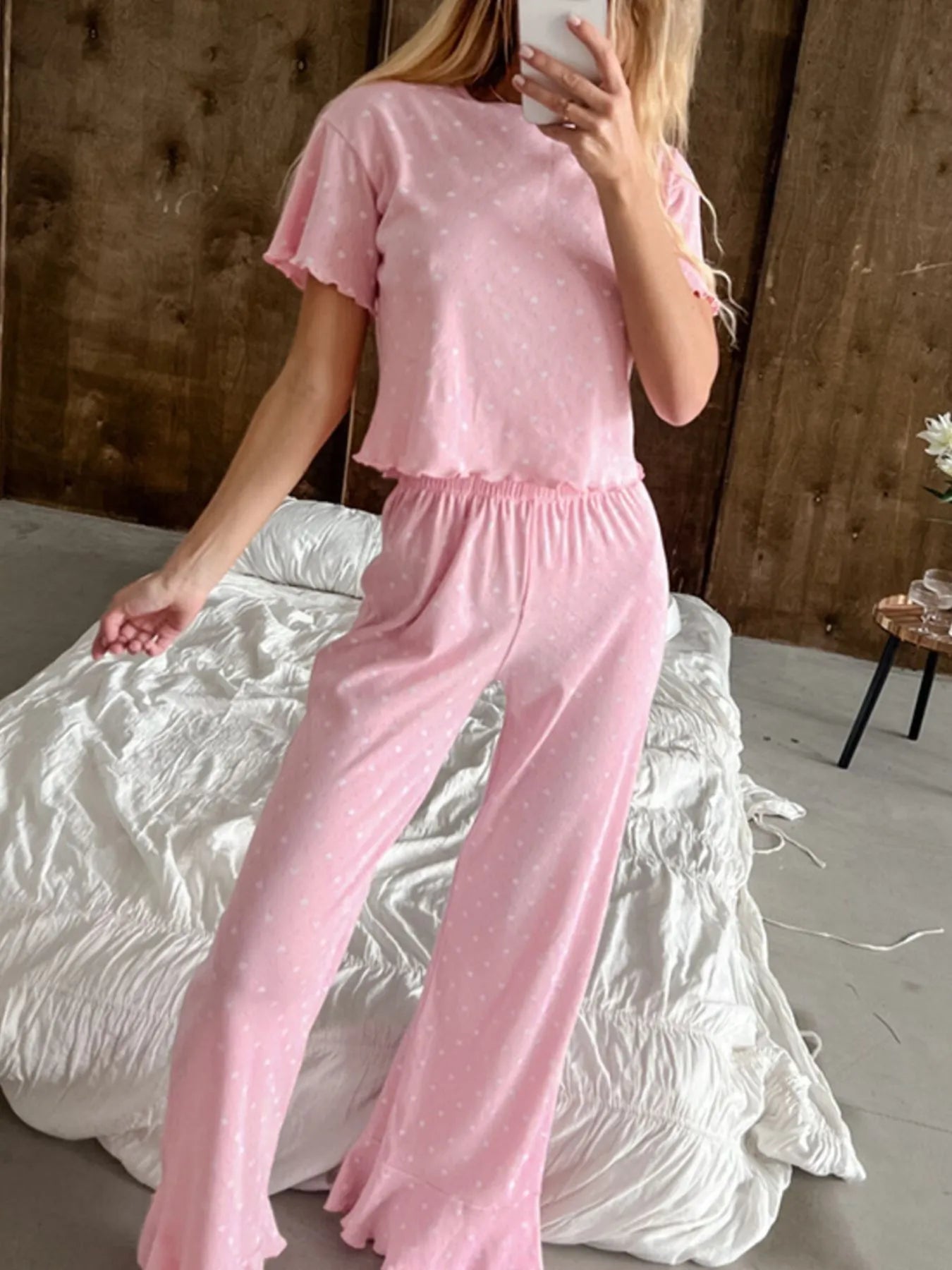 Pink polka dot round neck top and pants lounge set with ruffled edges, slightly stretchy polyester fabric.