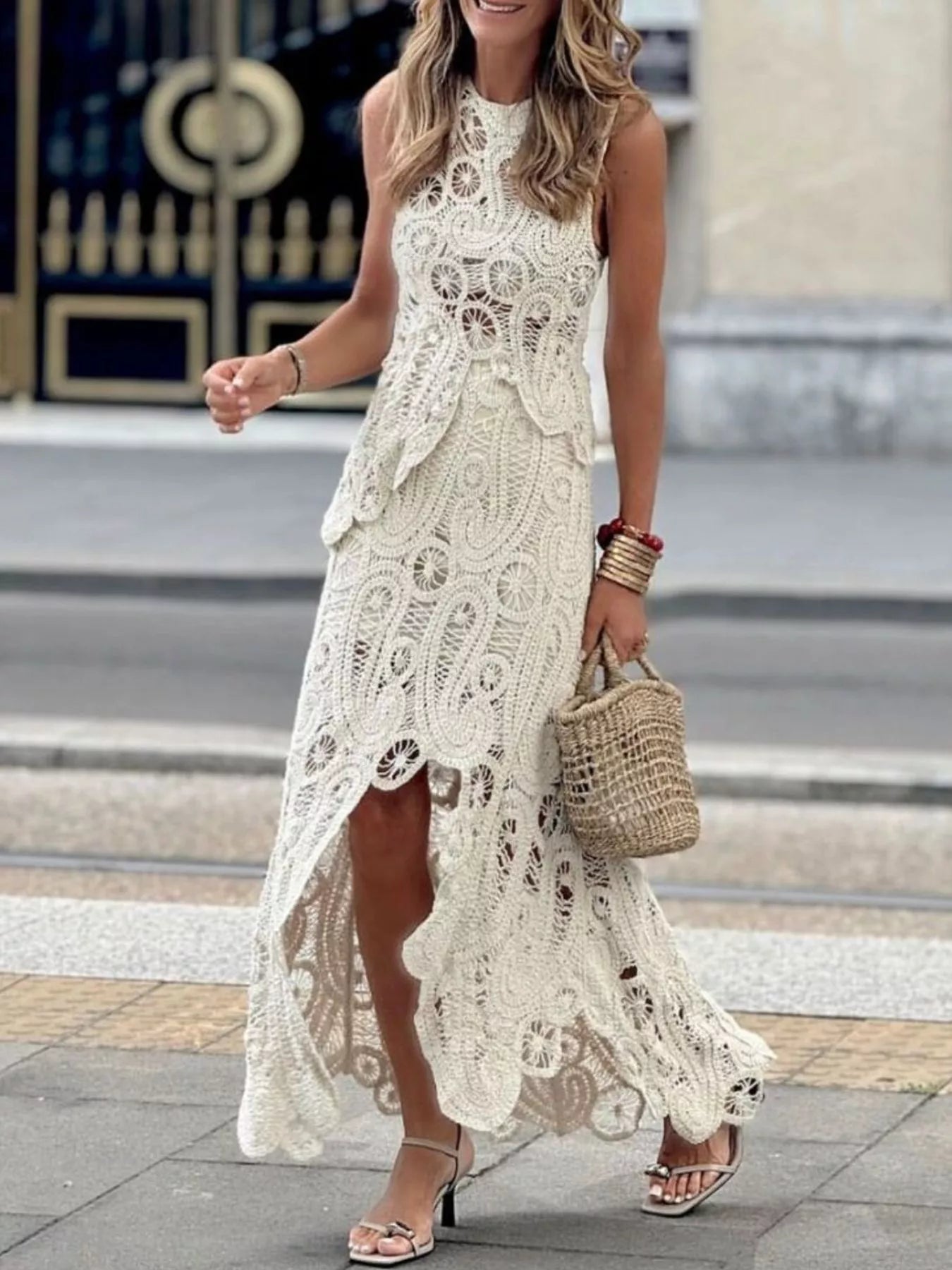 Woman wearing white crochet sleeveless tank and asymmetrical skirt set with openwork design outdoors