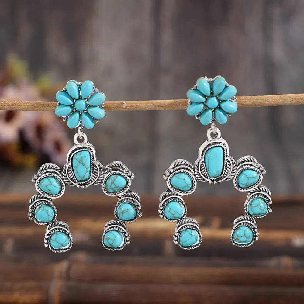 Pair of artificial turquoise alloy dangle earrings with floral and crescent designs
