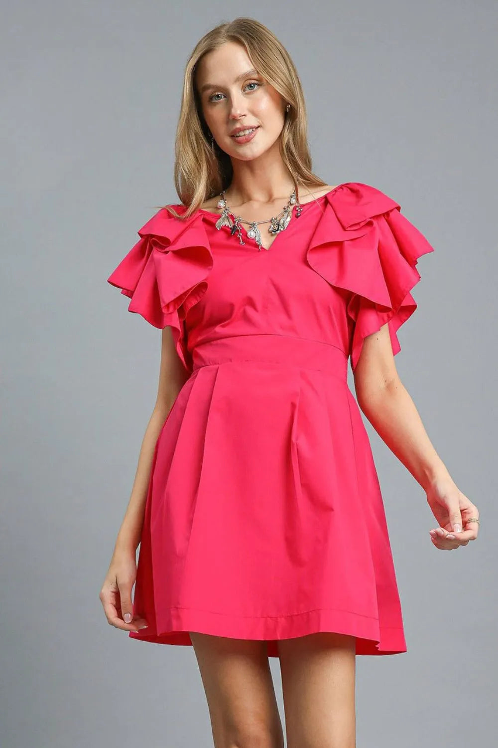 Woman wearing hot pink Umgee Double Ruffle Sleeve Dress with tiered ruffled sleeves and fit-and-flare silhouette
