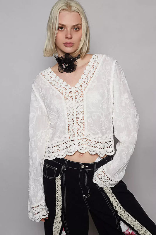 POL Long Sleeve Cropped Crochet Top with floral embroidery in white, modeled with black pants.