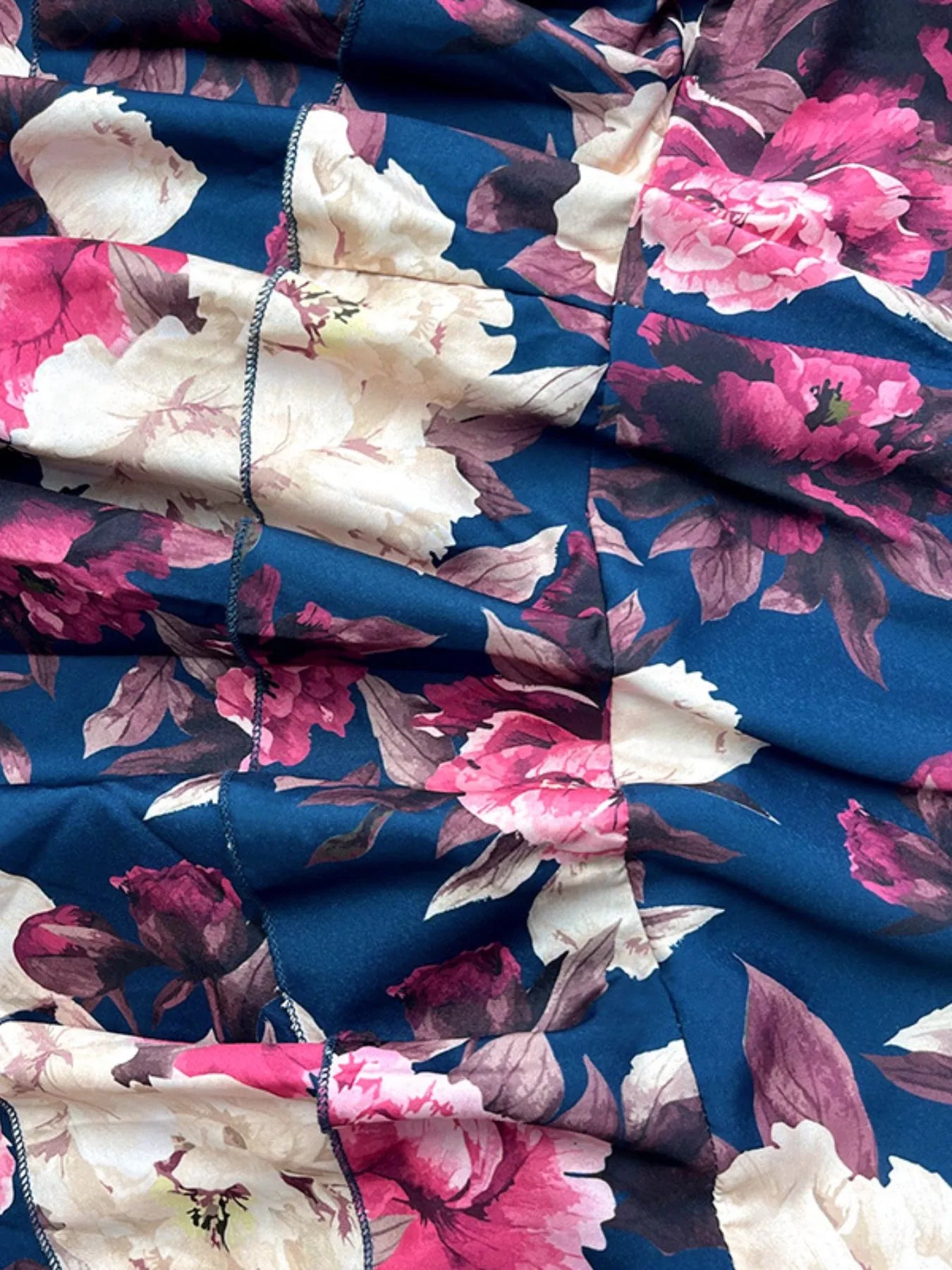 Close-up of full size floral cami and layered skirt set fabric with pink and white flowers on navy background