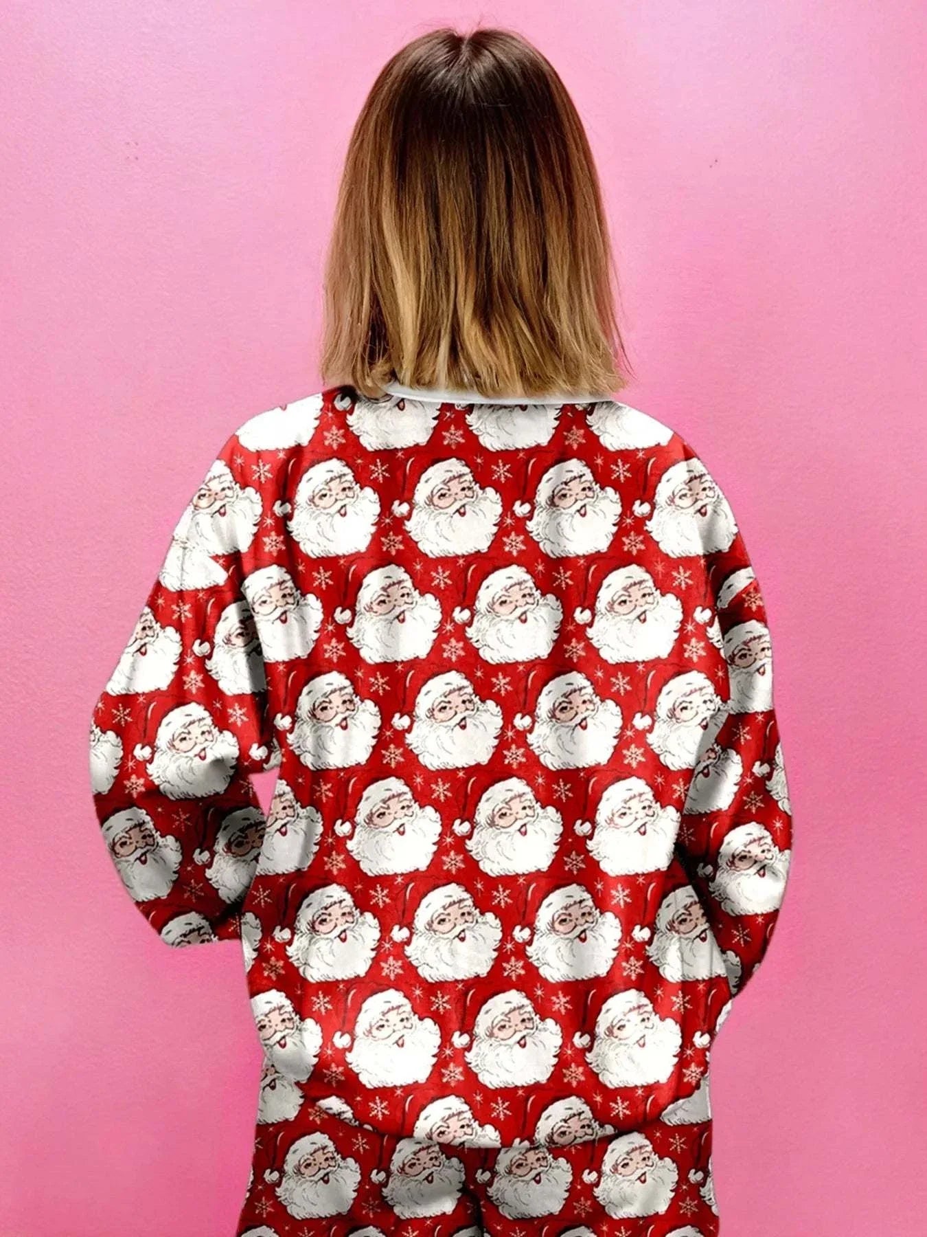 Woman wearing Christmas Santa print round neck top and shorts lounge set with red background and Santa faces pattern