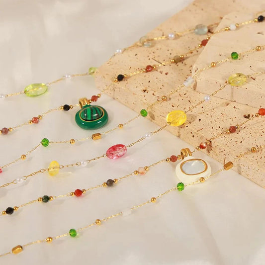 Two-piece set of titanium steel gold-plated bead necklaces with synthetic pearls and natural stones, including malachite and drip oil accents.