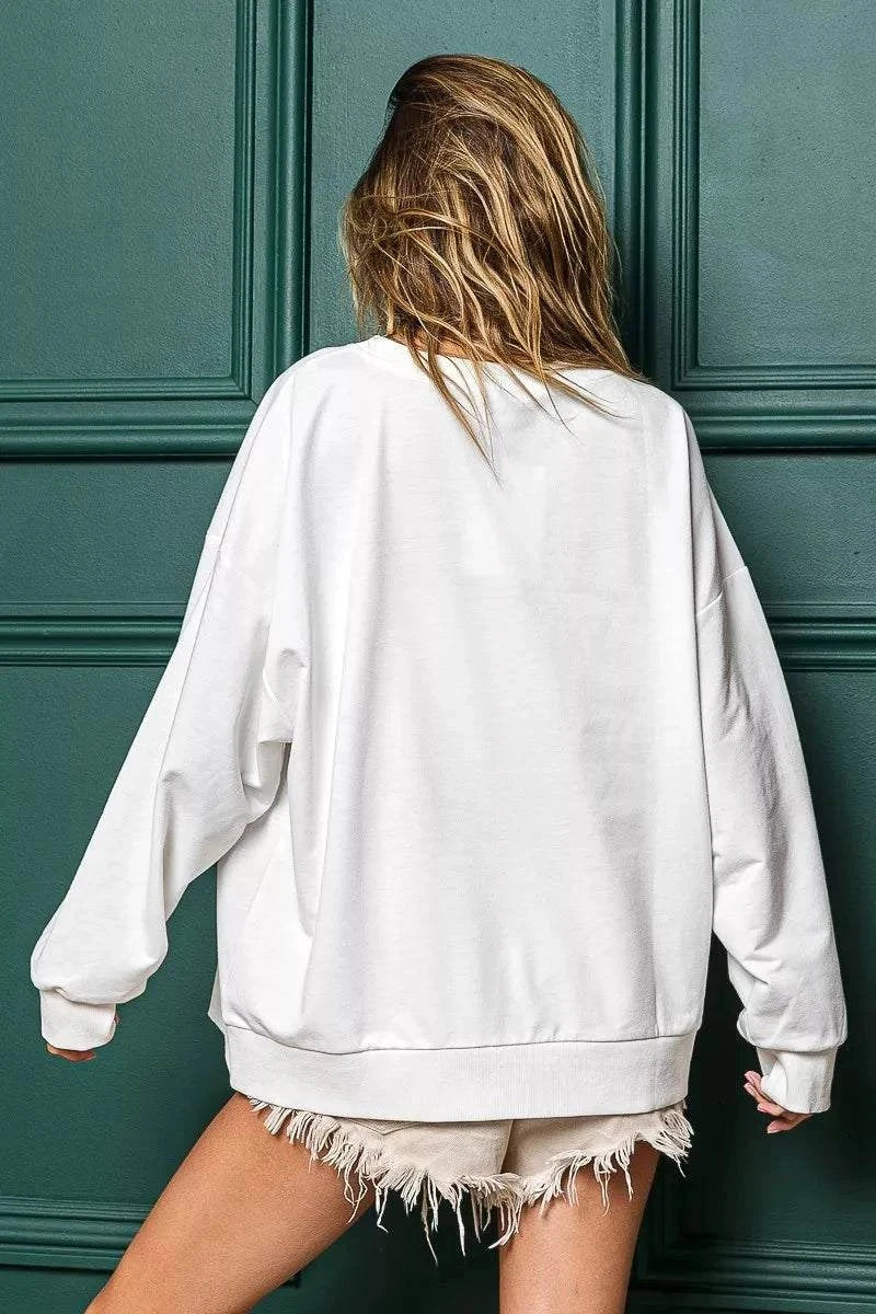 Back view of oversized white Holly Jolly Christmas French Terry Sweatshirt paired with distressed shorts