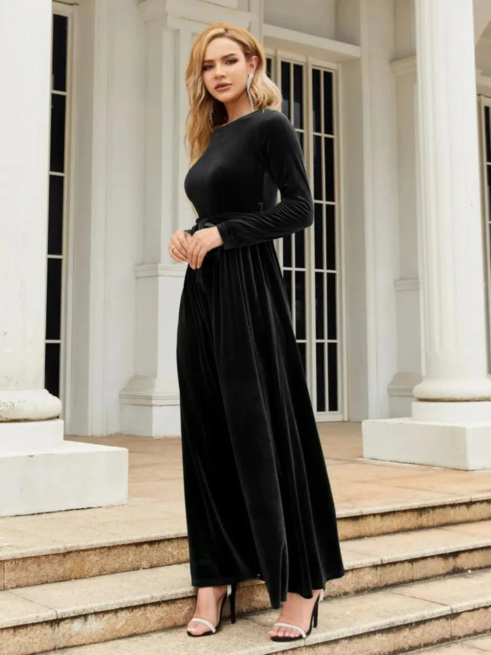 Woman wearing black tie front round neck long sleeve maxi dress standing outdoors
