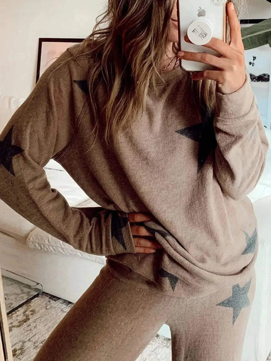 woman wearing brown star print top and drawstring pants set taking mirror selfie