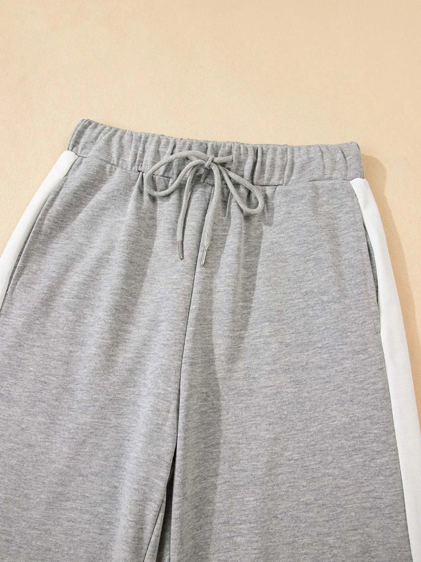 Grey drawstring pants with white contrast trim sides from two-piece set