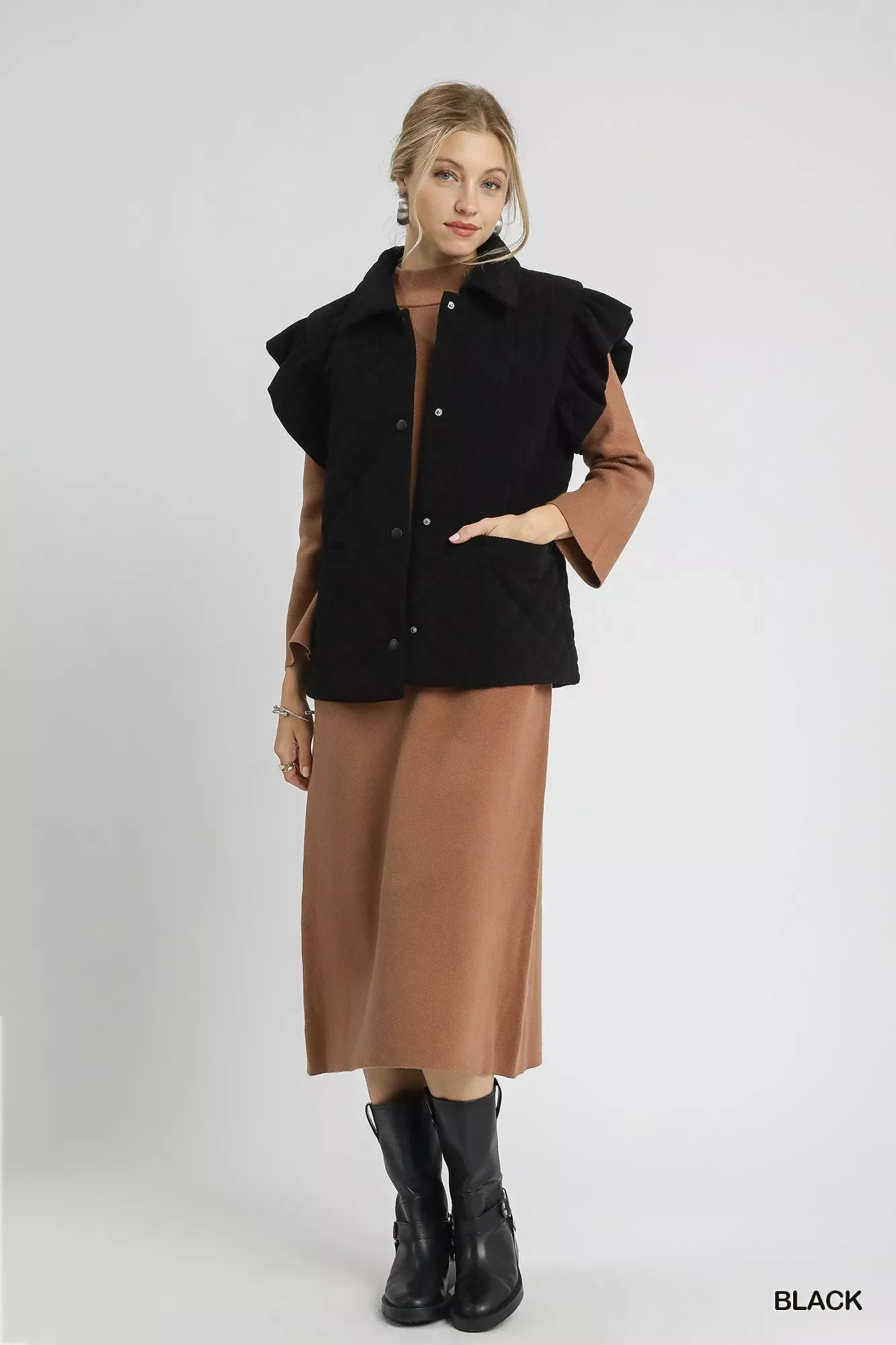 Woman wearing black Umgee Corduroy Quilted Ruffle Sleeve Vest over brown dress with black boots
