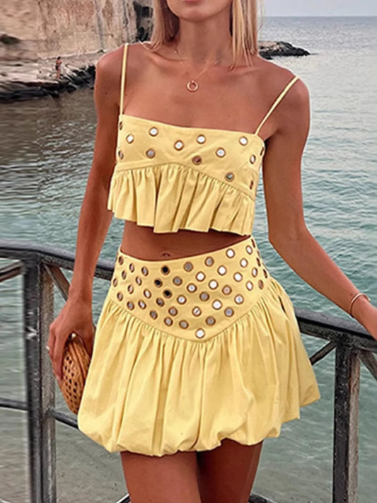 Yellow eyelet cami with ruffled hem and matching bubble skirt set worn by a woman by the sea