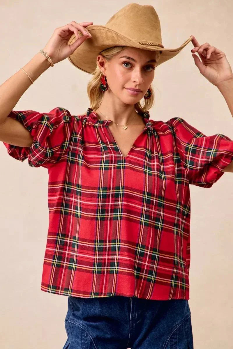 BiBi Christmas Plaid Short Sleeves Ruffled BlouseThis Christmas plaid short sleeves ruffled blouse is a festive and charming addition to your holiday wardrobe. The classic plaid pattern evokes a cheerful and cozy hChristmas plaid blouse
