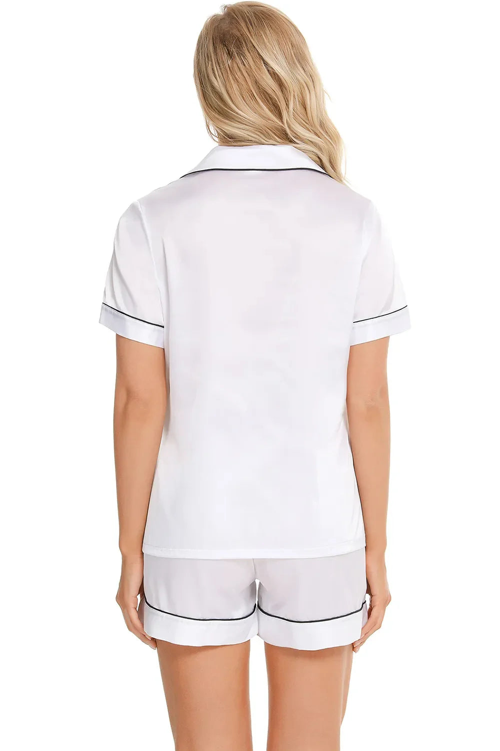 Back view of woman wearing white sheer printed button up short sleeve top and shorts lounge set with black trim