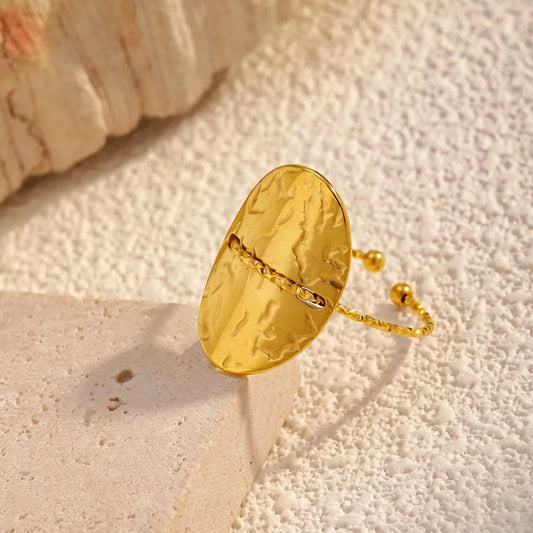 18K gold-plated hammered disc open ring with stainless steel adjustable band on textured surface