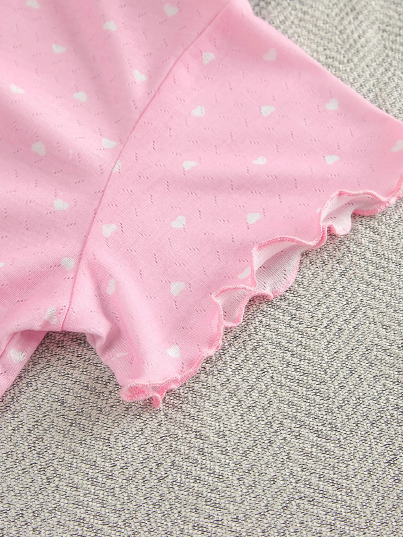 Close-up of pink polka dot round neck top with ruffled sleeve edge in lounge set