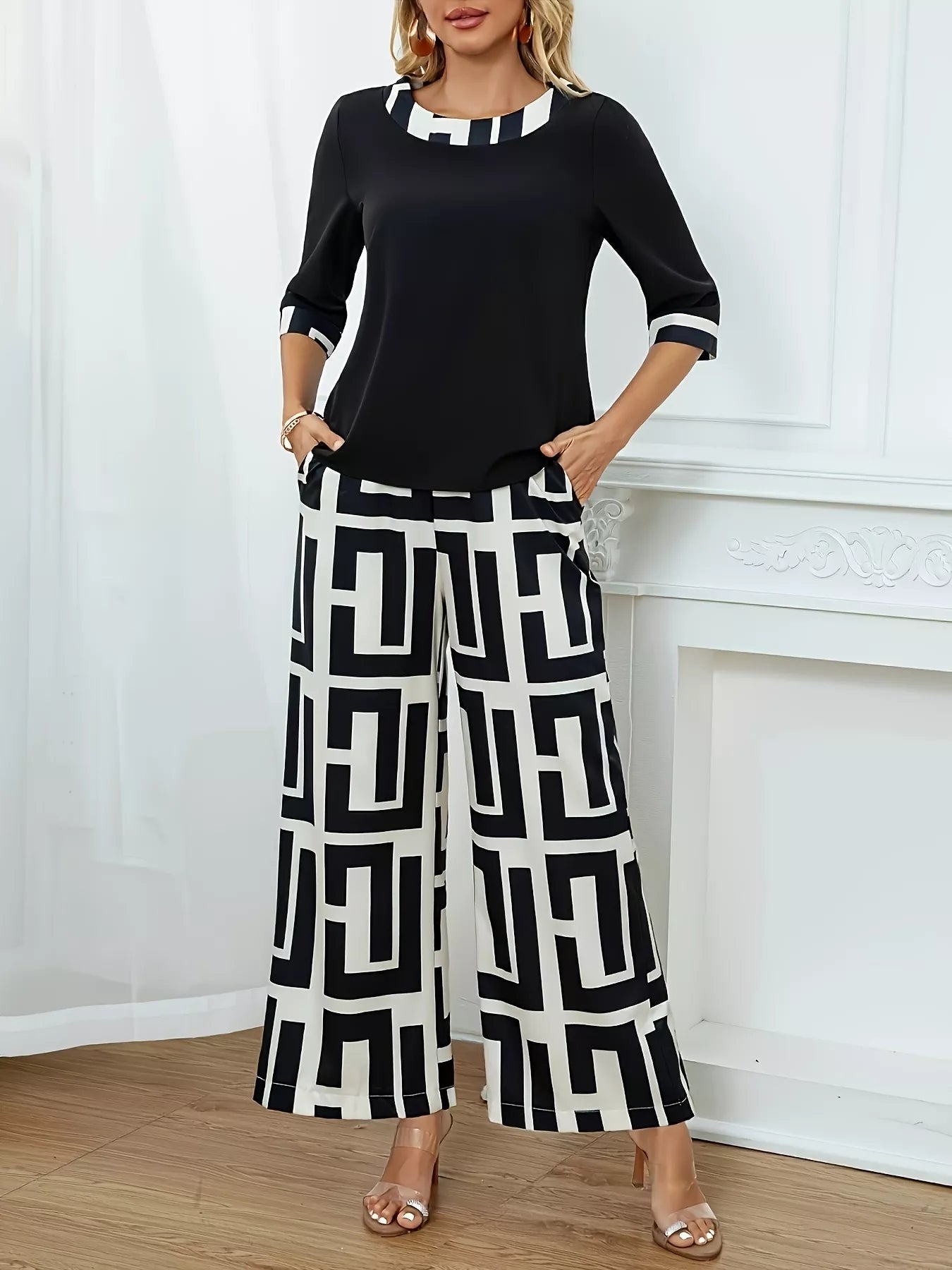 Woman wearing geometric print round neck top and matching wide-leg pants two-piece set with black and white pattern