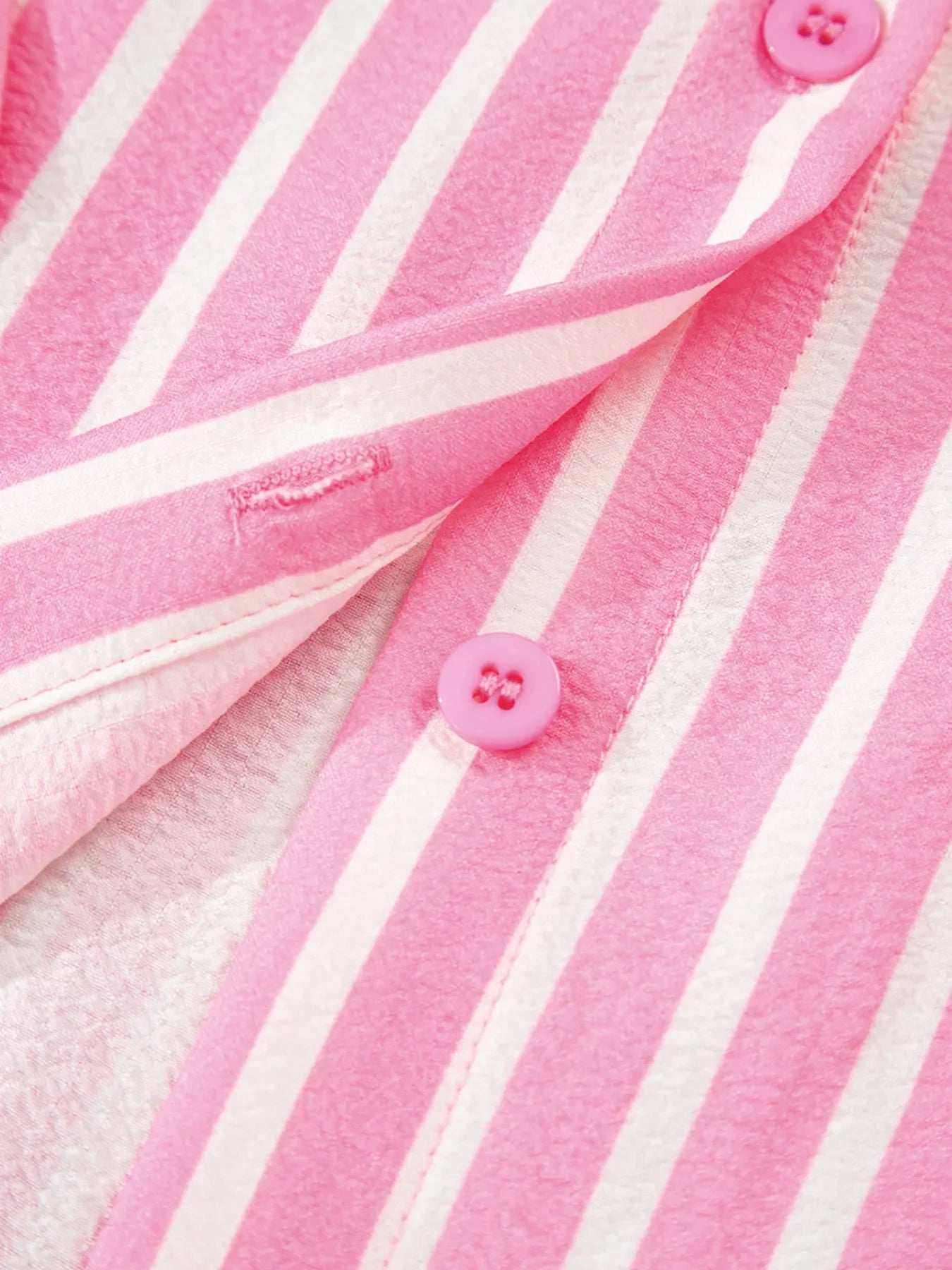 Close-up of pink and white stripe buttoned front sleepwear top with pink buttons