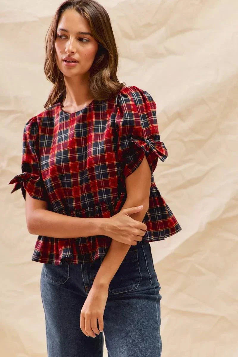 Woman wearing Christmas holiday plaid ribbon short sleeves top with tied sleeves and ruffled hem