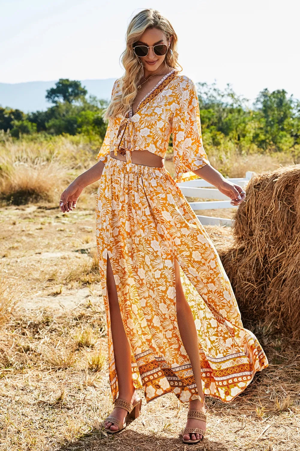 Woman wearing printed half sleeve top and slit skirt set in outdoor field setting