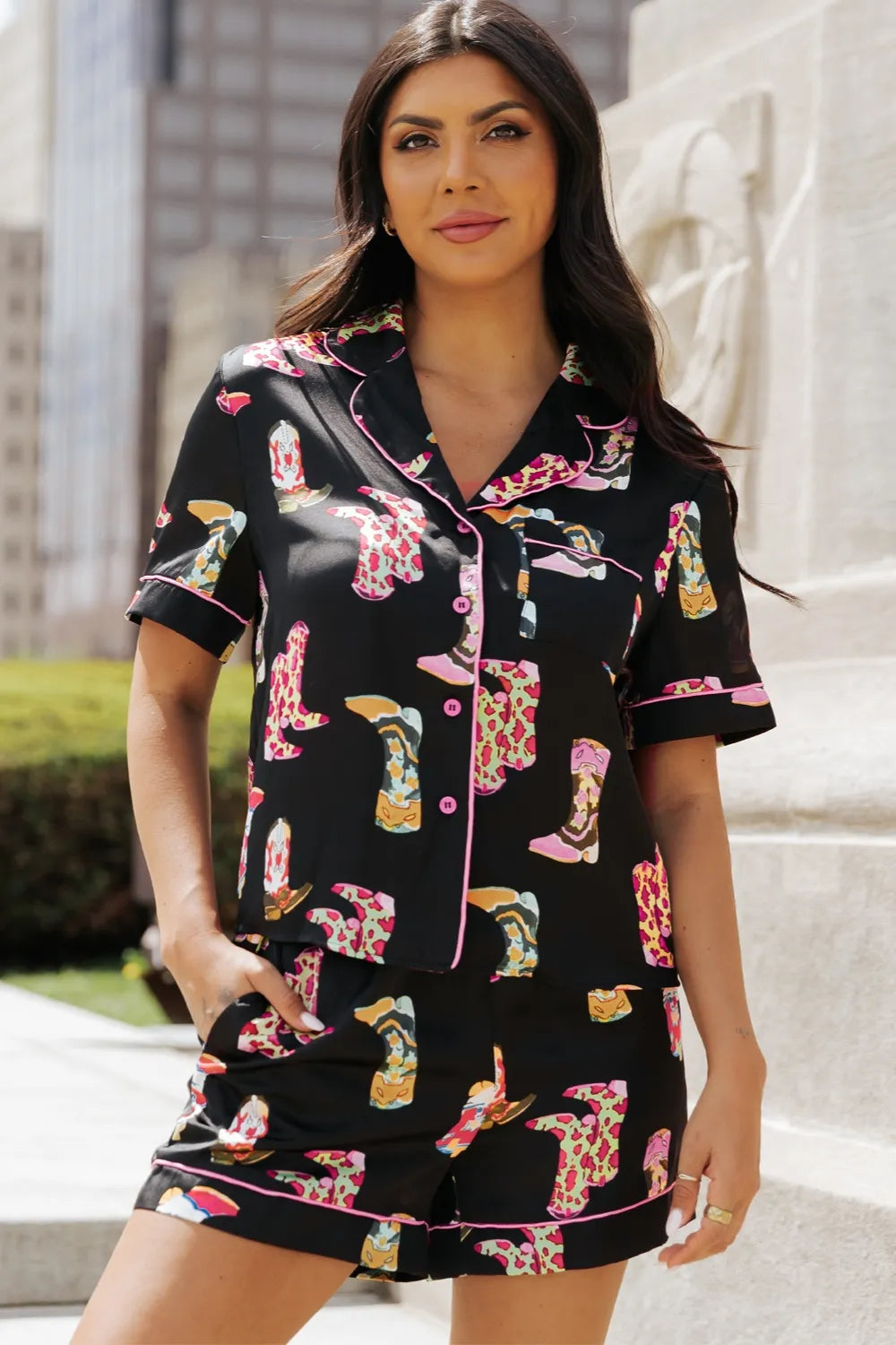 Woman wearing printed button up short sleeve top and matching shorts lounge set outdoors