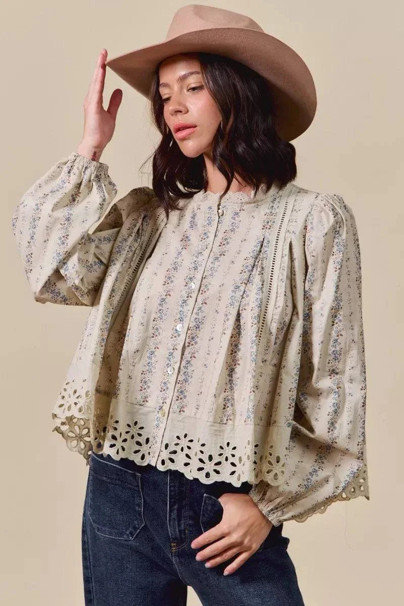 Floral print lace button-down shirt with lace detailing and ruffled sleeves worn with a hat