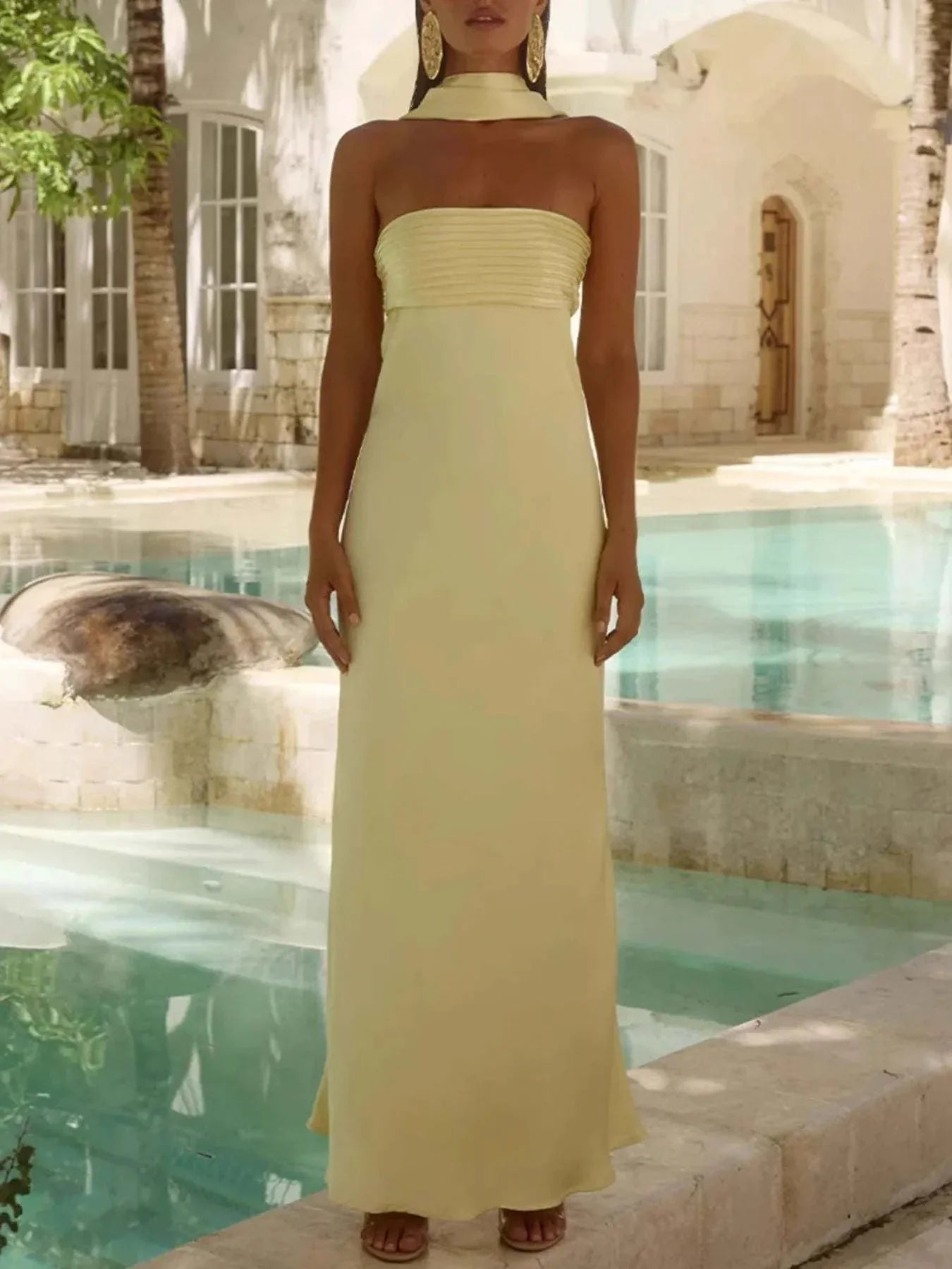 Elegant pale yellow tube mermaid maxi dress with strapless design and straight silhouette by the poolside