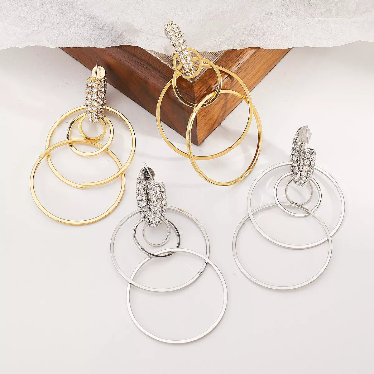 Pair of gold and silver rhinestone hoop dangle earrings with multiple circular hoops and detailed rhinestone accents