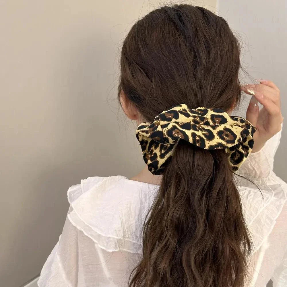 Leopard elastic hair scrunchy holding long brown hair in a ponytail