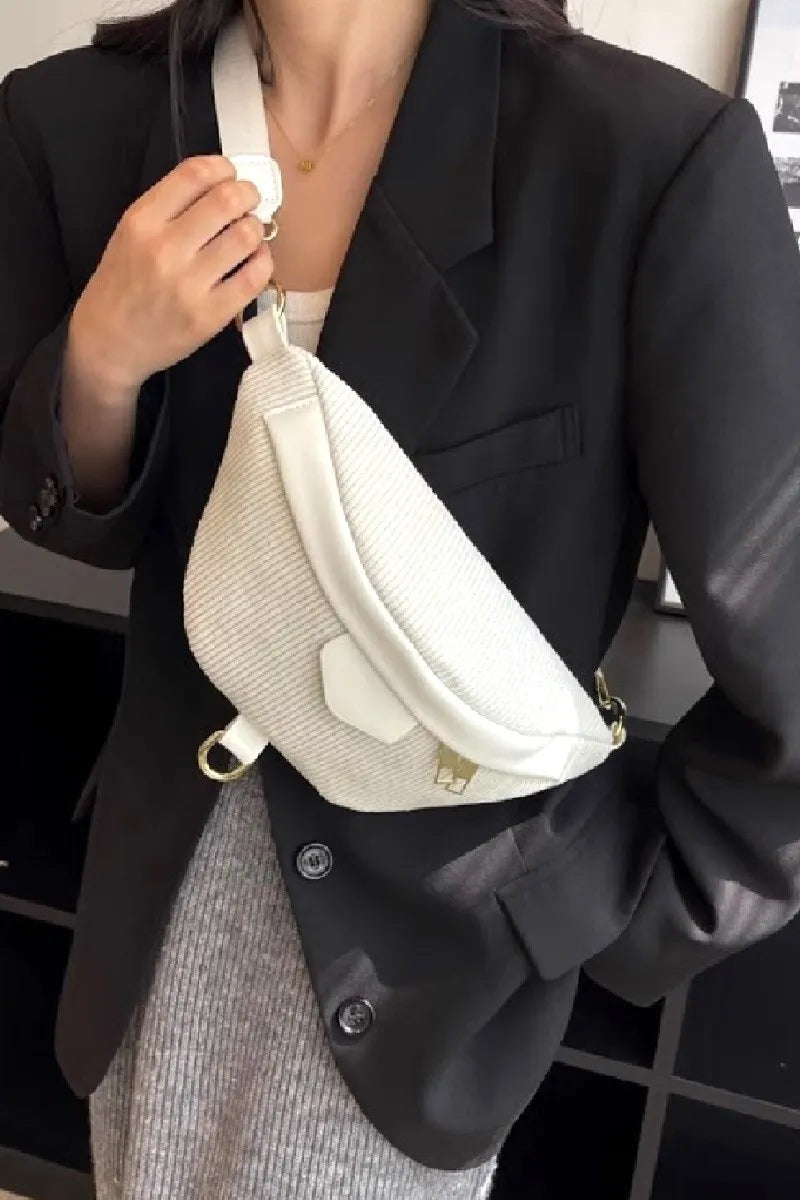 White corduroy crossbody bag with removable strap worn with black blazer and gray skirt