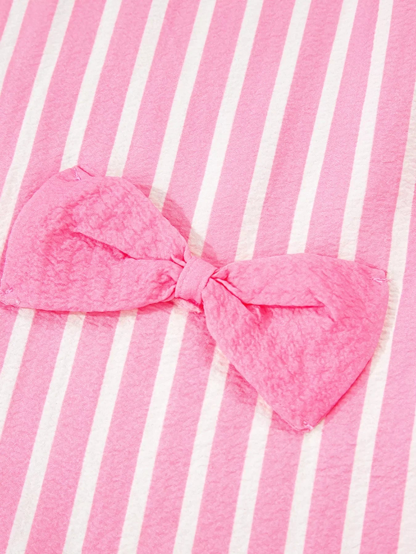 pink and white striped fabric with pink bow detail on stripe buttoned front sleepwear top