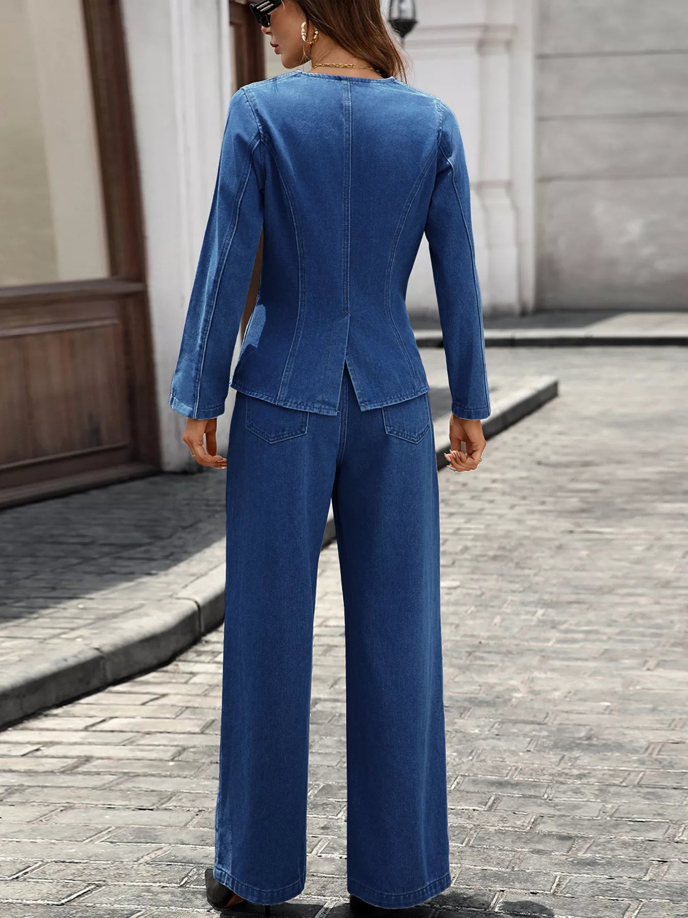 back view of woman wearing blue button up long sleeve top and denim jeans set on street