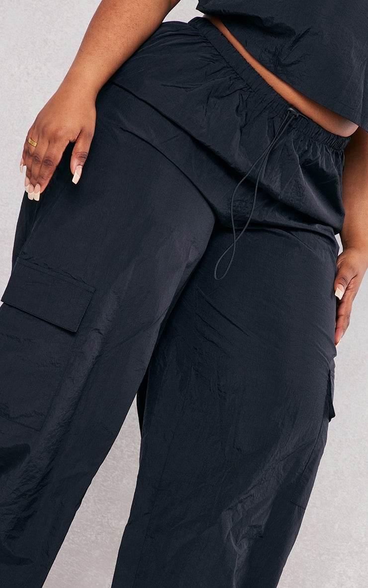 Plus Black Nylon Wide Leg Cargo TrousersReimagine your everyday uniform with these black nylon wide-leg cargo trousers. Cut from a durable, subtly textured nylon, they offer both structure and a relaxed siRedemption By Ashley NorthPlus Black Nylon
