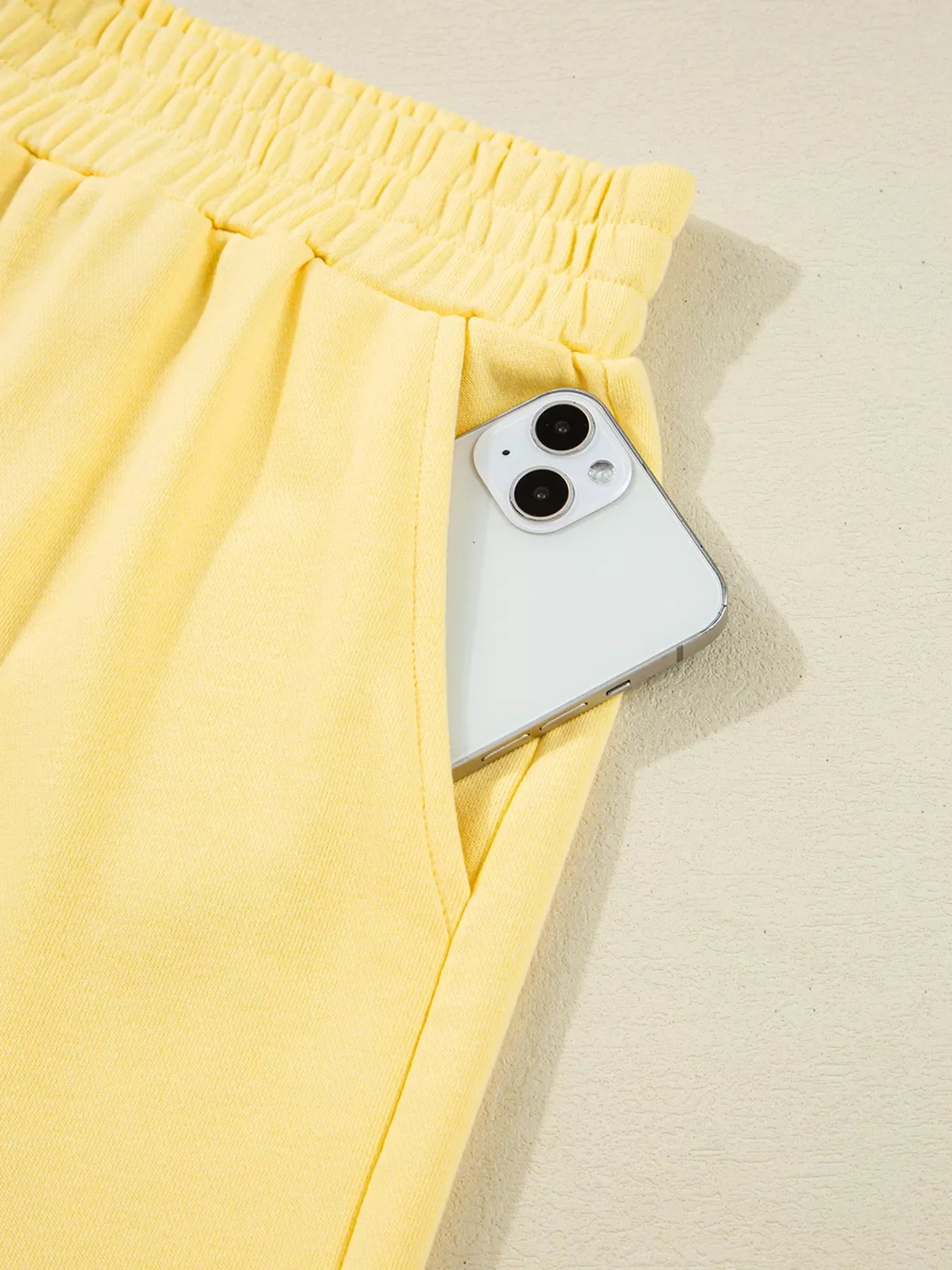 Yellow patchwork shorts pocket with smartphone showing color block patchwork design